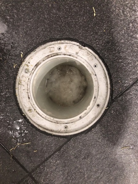 A drain access point opened at ground level