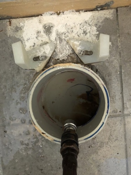 A drain machine cable fed into the floor waste where a toilet has been lifted