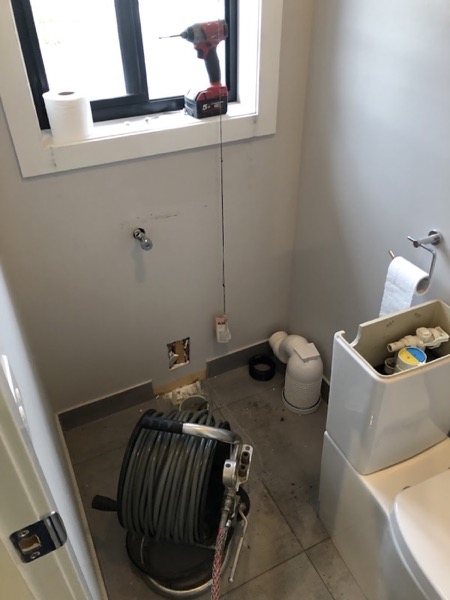 A drain machine set up beside a lifted toilet in a Ballarat bathroom